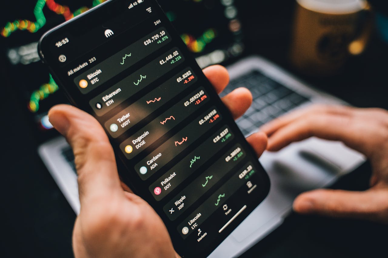Person holding smartphone showing cryptocurrency market data, symbolizing digital investment tools.